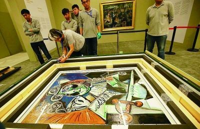 上午，法方工作人员对毕加索的画作拍照验明正身 摄 法制晚报记者 林晖