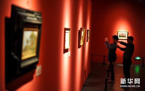 3月28日，参加画展开幕式的参观者在观赏画作。 