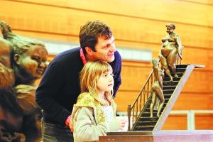 一对法国父女在罗浮宫卡鲁斯厅“欢乐岭南”大展上欣赏胖女雕塑