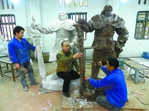 昨天，刘烈成（中）正在指导工人制作网游武士雕塑。重庆晨报记者 陈军 摄