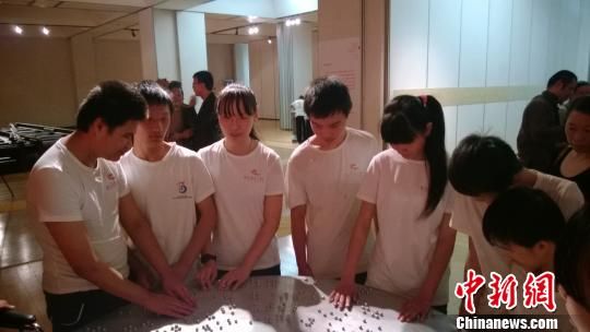 视障孩子在用手感受雕塑。　张骏　摄