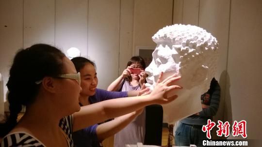 视障孩子在用手感受雕塑。　张骏　摄