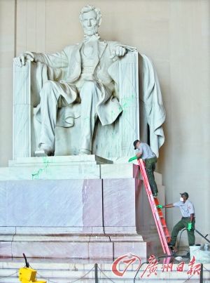 图为国家公园管理处工作人员在现场清除油漆。