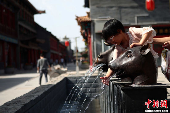 仿制的“圆明园十二兽首铜像”成孩童嬉水的玩具