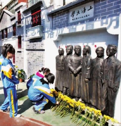 今天上午，学生以及社区居民向纪念墙默哀，并献上鲜花 本报记者 楼文彪 摄