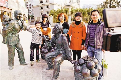 2月17日，重庆梁平县城乾街，市民在雕塑《柚香美滋味》前摄像留念。