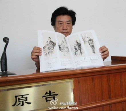 赵建成在庭审现场展示其“水墨写实作品集”，据他介绍，10幅赝品中有7幅均仿自这本画集。