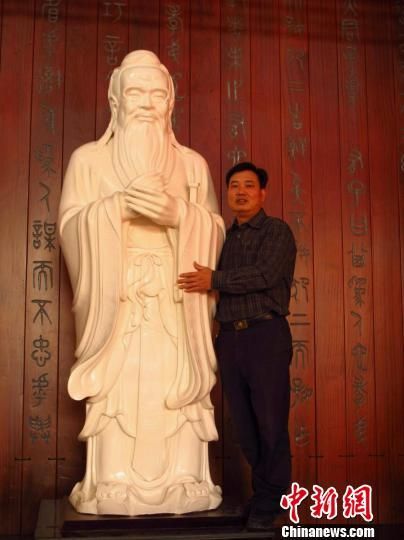 图为获吉尼斯世界纪录的孔子瓷雕塑像与创作者福建省工艺美术大师赖礼同。 王双季 摄