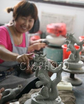 9月5日，女青年农民工艺美术师在制作车间对《腾龙》汝瓷作品进行深加工。