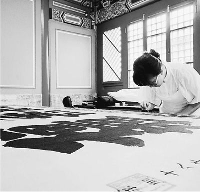 故宫博物院工作人员正在为绣字康熙帝御笔万寿无疆匾除尘、清理