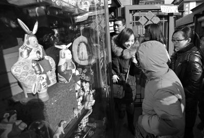 厂甸庙会，一家卖兔爷的小店生意火爆，市民需要排队进店。
