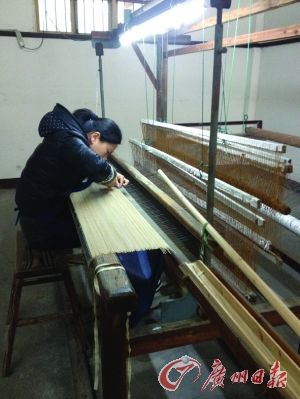 工人在细心编制捞纸的竹帘。手工宣纸能隐约看到竹帘纹。