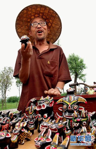 在河南省淮阳县太昊陵庙会上，一位民间艺人在售卖他制作的民间泥塑工艺品。