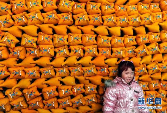  在河南省淮阳县白楼乡庞庄村，一位女孩站在堆满“布老虎”的屋内玩耍。“布老虎”是一种流行于豫东一带民间的传统手工艺品。