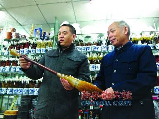 夏高(左)与父亲查看以祖传工艺制作的毛笔。记者 徐盛伟 摄