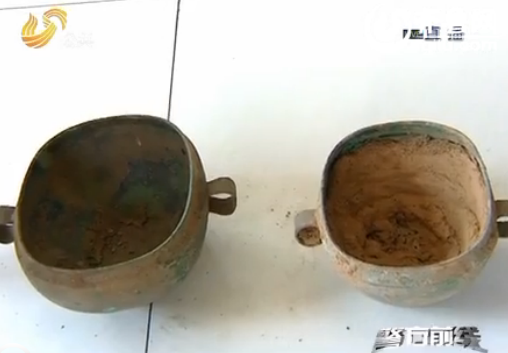 盗墓团伙挖出了两件30厘米高的青铜器和部分青铜器碎片（视频截图） 
