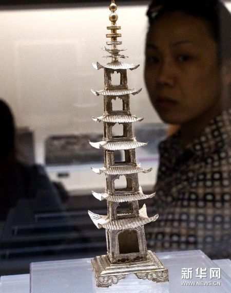 6月7日，游客在考古展上观看距今500多年的银塔工艺品。