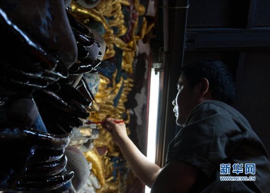 5月7日，文物修复人员在为千手观音造像的手部进行修复。新华社记者 刘潺 摄