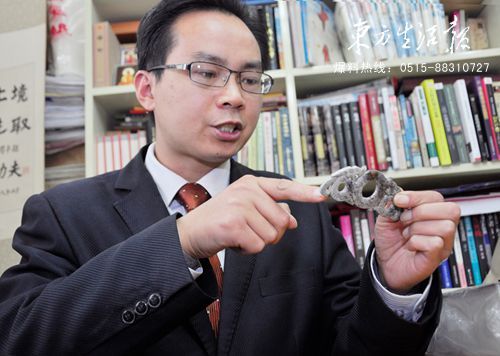 蔡云桂向记者展示他收藏的西汉玉器——双龙出廓璧