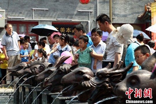 6月1日，一组仿制“圆明园十二兽首铜像”在山西太原食品街正式亮相，诸多市民与这具有特殊意义的兽首合影留念。　张云 摄