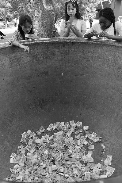 雍和宫内，供应喇嘛煮茶用的大缸铺满了钞票。