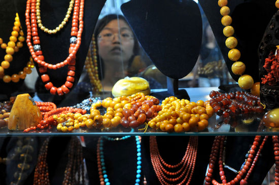 7月10日，一名顾客在2014中国昆明泛亚石博览会上选购特色珠宝首饰。资料图