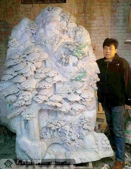 李玟翰和他正在雕刻中的大型玉雕作品《香山九老》。