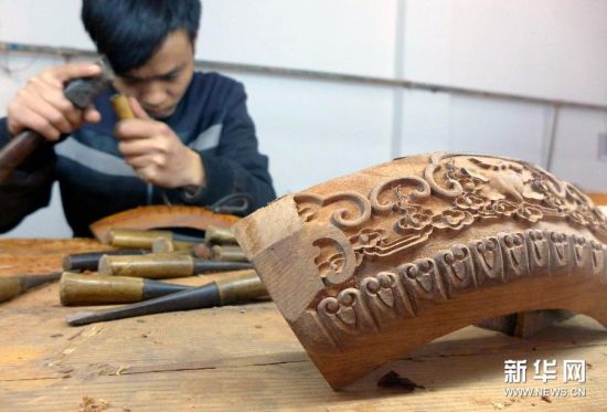 12月10日，河北青县一家红木家具企业的工人在雕刻家具纹饰。