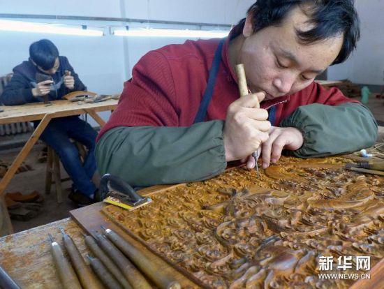 12月10日，河北青县一家红木家具企业的工人在雕刻家具纹饰。
