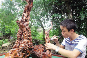 铁匠村村民在打磨花梨木工艺品。海南日报记者武威 摄 