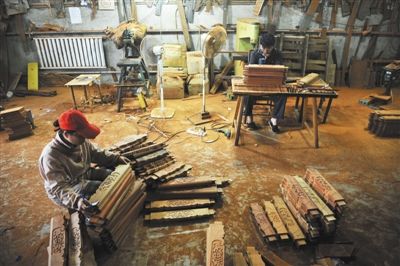 红木家具在开料、打磨、雕刻等生产阶段仍需要工人手工完成。新京报记者 李飞 摄