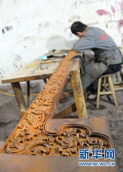 青县流河镇某雕刻企业工人们正在雕刻家具。