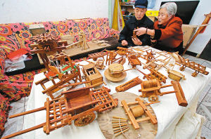 老两口展示老式农具模型 记者 刘珂 摄