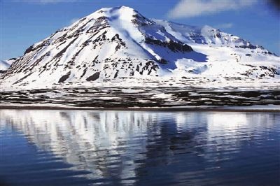 ■ 白雪覆盖的山坡倒映在平静的湖面上，整个画面都是白与蓝的共鸣