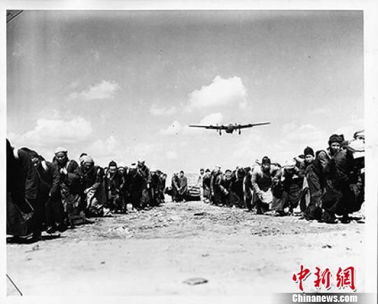  1944年3月31日，照片所示体现了现代机械与传统民工的强烈对比，表现这群中国民工奋力拖拉一个巨石碾子滚过跑道，用血肉之躯修建机场铺筑通往民族解放之路。　资料图　摄