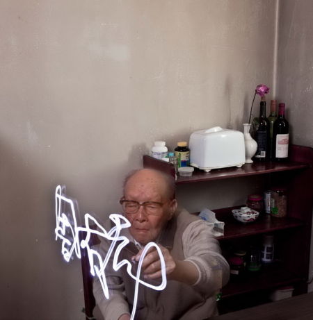 刘香成仿照他的摄影老师基恩·米利拍摄毕加索时让毕加索执着画笔绘画的创意，同样让周有光(汉语拼音之父)拿着笔书写“中国”和自己的名字。在这样“摆拍”下，镜头中的人物被赋予了一种主观的阐释。