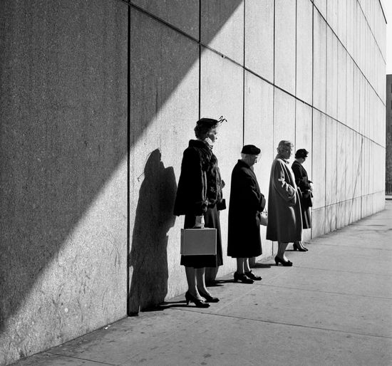 一排站在墙边的妇人，留白给人无限遐想与猜测。