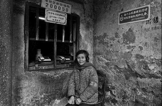 ②1988年上海，里弄传呼室门口执勤的阿姨管着一片住家的来往电话。