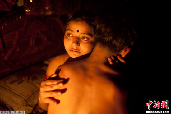 孟加拉国妓女。2012年3月4日，在孟加拉国东北部城市坦盖尔的妓院里，十七岁的妓女哈市拥抱着一位长期顾客。许多年轻的孟加拉国妓女有长期的顾客，称为“情人”或者“丈夫”。在这个男性占主导的社会里，他们通常不住