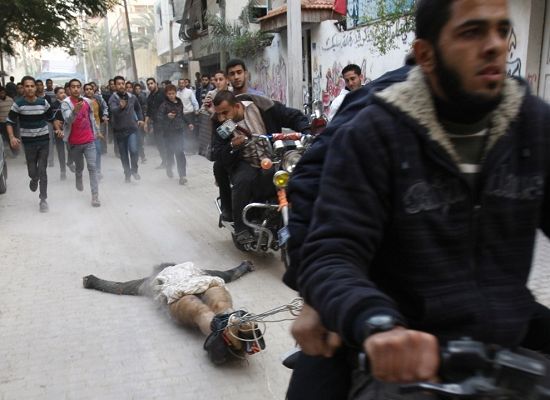 焦点新闻类单幅三等奖《叛徒》：在巴勒斯坦，一骑摩托者正拖着一名涉嫌与以色列通敌者的尸体沿街示众。(巴勒斯坦摄影师Adel Hana拍摄)