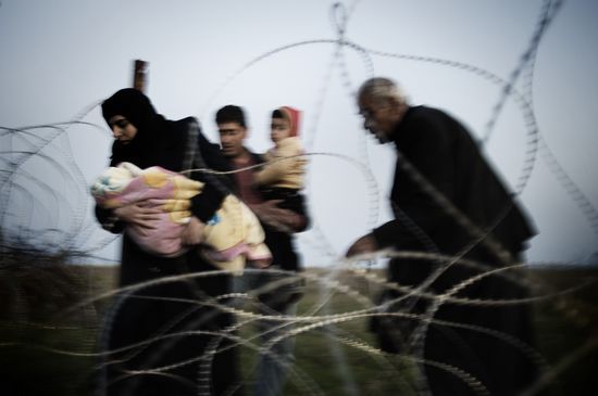 获奖作品《叙利亚之困》，在顾铮看来，这张拍摄人们扶老携幼在夜色中跨境逃难的照片，尽管由于失焦导致了模糊，但是，充满了诗意。