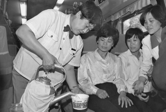 这是1993年拍摄的京广铁路线上的列车员王艳华在为旅客服务。(新华社记者 唐召明/图)