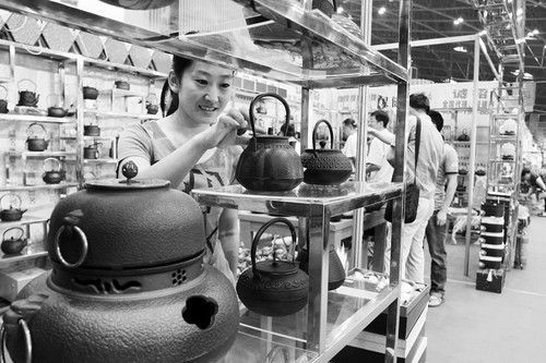图为参观者正在欣赏由台湾展商带来的台湾工艺铁壶。