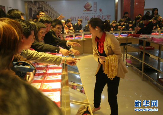 2013年4月25日，为了公平，杭州航民百泰首饰有限公司工作人员小心翼翼、一件一件地分发黄金首饰。