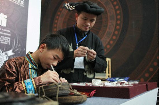 李正云和李晨父子二人在北京向参展游客展示银饰制作工艺 王敬 摄