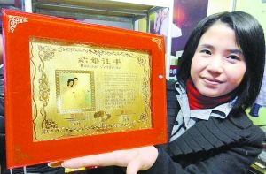 一家金店的工作人员在展示一款黄金“结婚证书”。新华社发