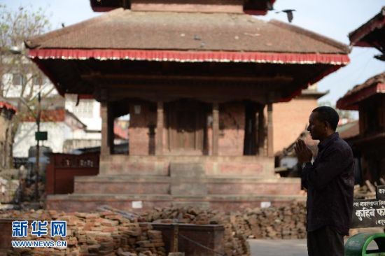 5月5日，在尼泊尔加德满都杜巴广场上，一名市民在祈祷。