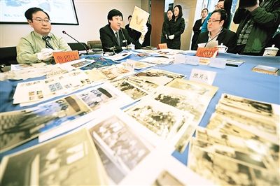 侵华日军南京大屠杀遇难同胞纪念馆馆长朱成山（左二）在捐赠仪式上展示鲁照宁捐赠的信笺。