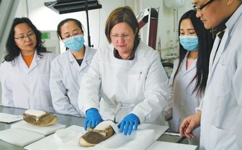 　德国专家与吐鲁番学研究院技术保护研究所成员一起检查皮鞋。 （图由吐鲁番学研究院技术保护研究所提供）