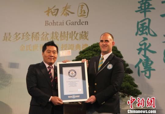 吉尼斯世界纪录认证师（右）向“柏泰园”主人陈万添（左）颁发“最多珍稀盆栽树收藏”认证书。 路梅 摄